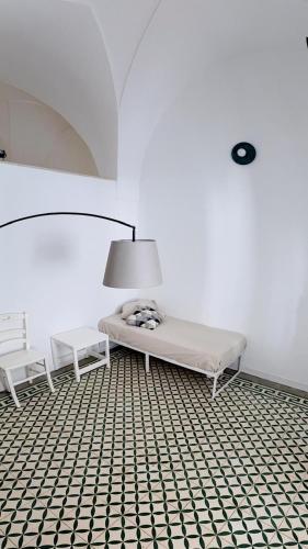 a white room with a bench and a lamp at Notos b&b in Otranto