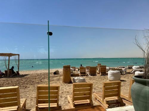 a beach with chairs and people on the beach at la Hacienda Cozy Studio Chalet in Ras Sedr