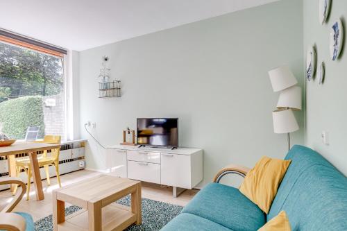 a living room with a blue couch and a table at Veluwe Nature Home - 2 persons in Otterlo