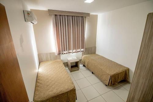 a hotel room with two beds and a window at Riviera Park in Caldas Novas