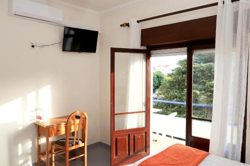 a bedroom with a door and a desk and a television at Residencial Braga in Vimeiro