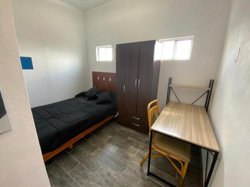 a small bedroom with a bed and a table at Rendiz in Mexico City