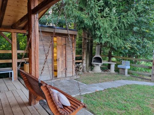 a hammock in front of a cabin with a fireplace at western cottage in Rečica ob Savinji