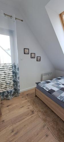 a bedroom with a bed in a room with a window at Garden Baltic II in Trzęsacz