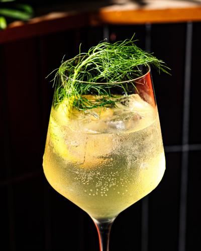 a glass of wine with a green grass garnishment at Fairlane Hotel Nashville in Nashville