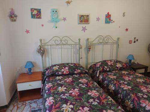 two beds sitting next to each other in a bedroom at Orchidea House in SantʼAntìoco
