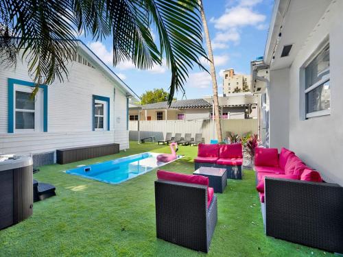 a backyard with red furniture and a swimming pool at Bungalow House 6 BR Pool Little Havana in Miami