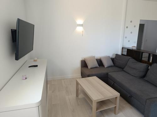 a living room with a couch and a table at Appartement avec vue exceptionnelle in Blanzat