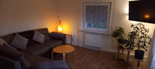 a living room with a couch and a table and a window at Ferienwohnung Lerchennest in Georgensgmünd