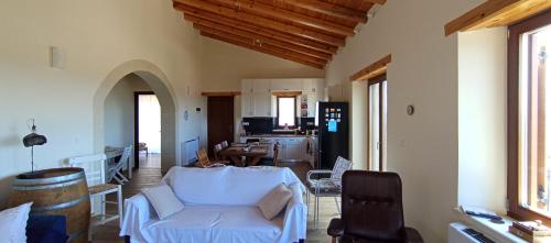 a living room with a white couch and a kitchen at Summer Villa with sea view,6 min drive from airport, near Seitan Limania beach in Khordhákion