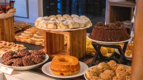 a buffet of different types of pastries and cakes on plates at Hotel Estoril in Campos do Jordão