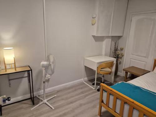 a room with a bedroom with a desk and a bed at Aafiyat House in Aldershot