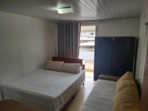 En eller flere senge i et værelse på Quitinete Balneário