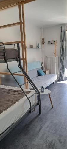 a bedroom with two bunk beds and a table at Aux pieds des pistes refait à neuf in Superdevoluy