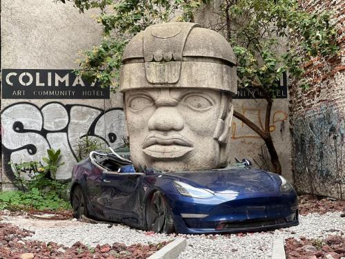 a car parked next to a statue of a head at Colima 71 - Casa de Arte Hotel in Mexico City