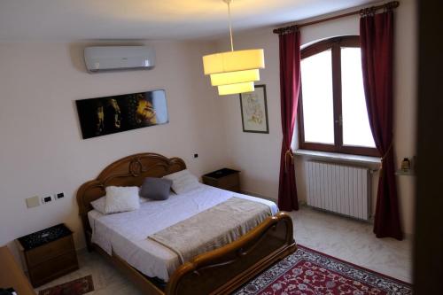 a bedroom with a bed and a window at Villa con giardino in Pontecurone