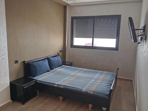 a bed in a room with a window at للا ربيعة بيتي in Kenitra