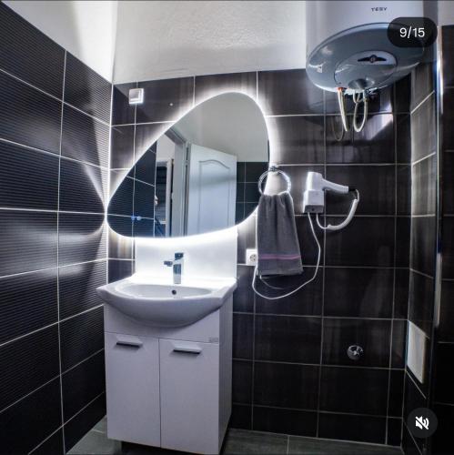a bathroom with a sink and a mirror at Apartman Nataša in Bosanski Novi