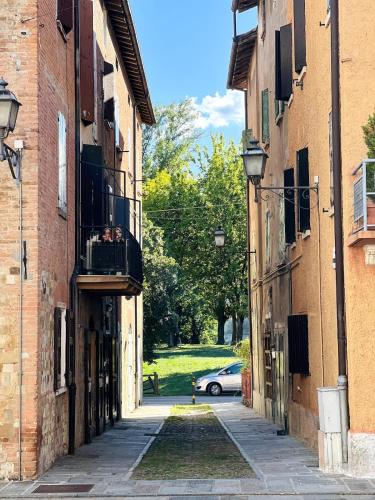 an alley between two buildings with a car at Appartamento Piazza Castello in Campogalliano