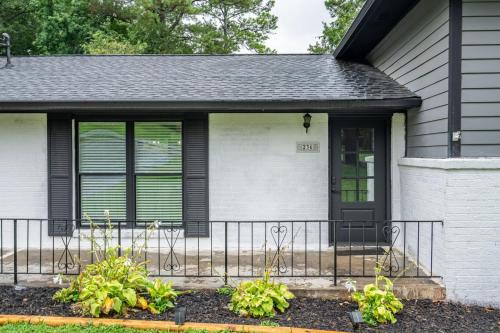 a house with a black door and a fence at Comfort & Space in Prime Cartersville Spot in Cartersville