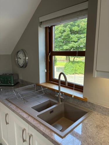 a kitchen counter with a sink and a window at Modern Country Loft, Ballymena in Teeshan
