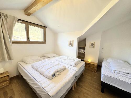 a bedroom with two beds and a window at Résidence Le Living Stone B - LIVING STONE B MAE-1781 in Vars