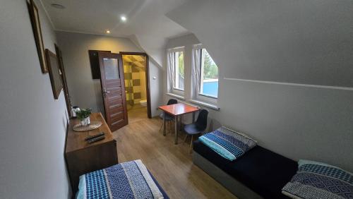 a small room with a bed and a desk and a table at Noclegi Mazur przysiersk in Przysiersk