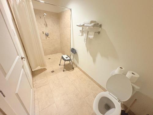 a small bathroom with a toilet and a shower at Westwood Inn Extended Stay by OYO Gonzales TX in Gonzales