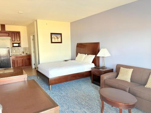 a hotel room with a bed and a couch at Westwood Inn Extended Stay by OYO Gonzales TX in Gonzales