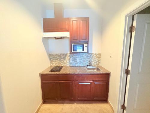 a small kitchen with a sink and a microwave at Westwood Inn Extended Stay by OYO Gonzales TX in Gonzales