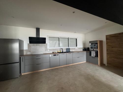 a kitchen with white walls and stainless steel appliances at Gîtes La Pagaille in Bournezeau