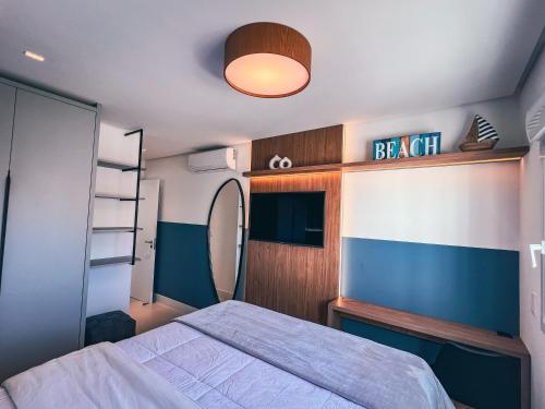 a bedroom with a bed and a light on the ceiling at Apê elegante, terraço Lindo e ótima localização in Capão da Canoa
