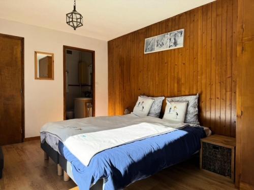 a bedroom with a large bed with a wooden wall at Résidence La Maison Blanche - Maison de village au coeur des Allues proche des commerces et de la télécabine MAE-9753 in Les Allues