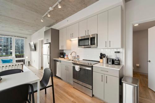 a kitchen with white cabinets and a table with chairs at 2BR City Escape Bright Sleek Spacious in Chicago
