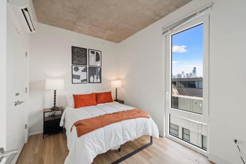 a bedroom with a bed and a large window at 2BR City Escape Bright Sleek Spacious in Chicago