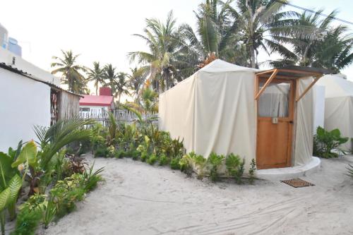 a tent on the beach with palm trees at Arena y Mar Seaside Glamping - Adults Only by The Spot Rentals in El Cuyo