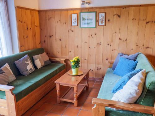 a living room with two green couches and a table at Carlo B Garten Ferienwohnung EG in Piantedo