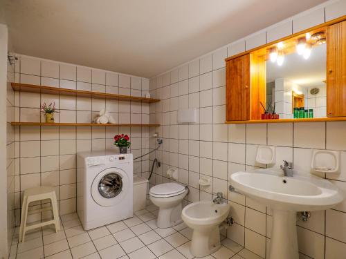 y baño con lavamanos y lavadora. en Carlo A Garten Ferienwohnung EG, en Piantedo