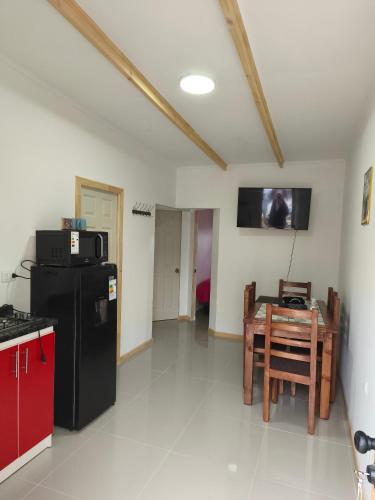 a kitchen with a black refrigerator and a table at Loftdonalejandro in Machalí