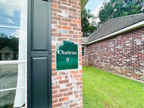 a green sign on the side of a brick building at Chateau 8 in Hammond
