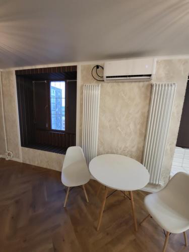 a room with two chairs and a table and a window at Апартаменты 2 in Karagandy