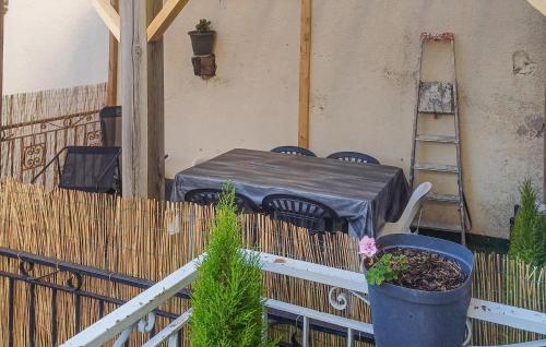 a patio with a table and chairs and a ladder at Gorgeous Apartment In Saint-Bonnet-Le-Châtea in Saint-Bonnet-le-Château