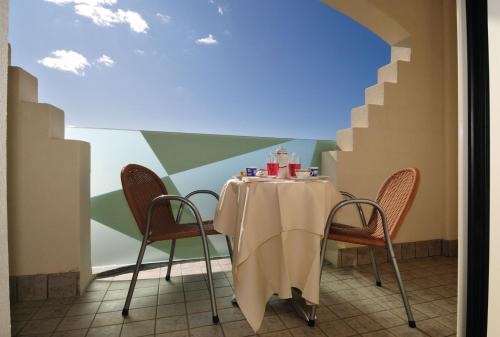 une table et des chaises dans une pièce avec un mur dans l'établissement Hotel Stella Marina, à San Vincenzo
