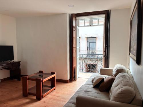 una sala de estar con un sofá y una mesa en Casa 621, en Cuenca