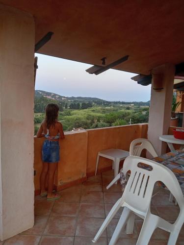 a woman standing on the balcony of a house at casa relax a chia in Chia