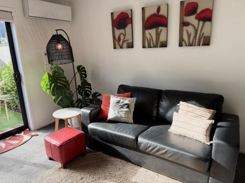 a black leather couch in a living room with paintings at CBD 2BDR 2Bath Casino TownHall TePae Convention center FREE carpark in Christchurch