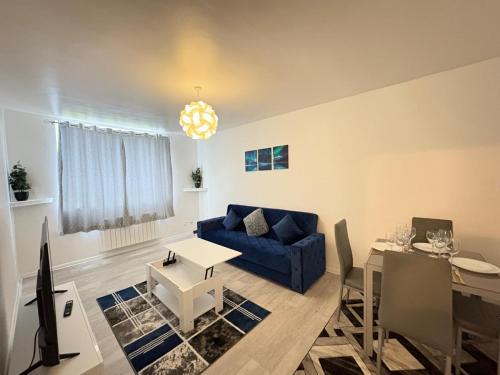 South NorwoodにあるCosy 2 bed flat Near East Croydonの青いソファとテーブルのあるリビングルーム