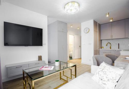 a living room with a tv on a wall at Apartament Glamour in Łańcut