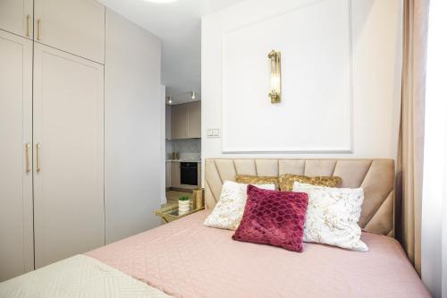 a bedroom with a bed with pink sheets and pillows at Apartament Glamour in Łańcut
