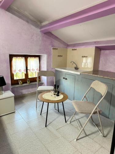 a kitchen with two chairs and a table and a counter at Studio Della Fiamma in Gubbio